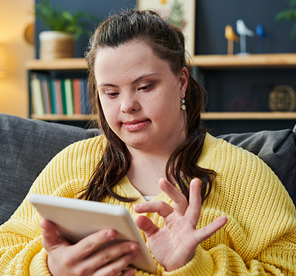 Young woman with Downs syndrome using a tablet