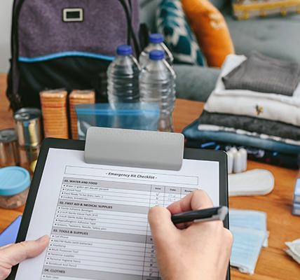 Person marking a sheet of paper on a clipboard